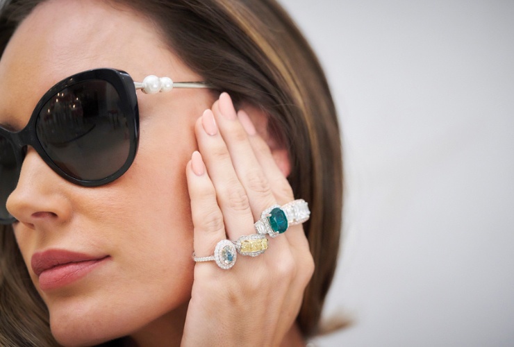 Woman wearing sunglasses and various rings